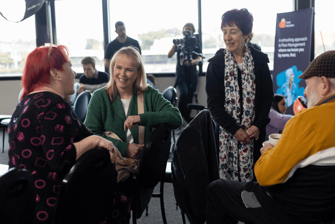 Three women and one man talking